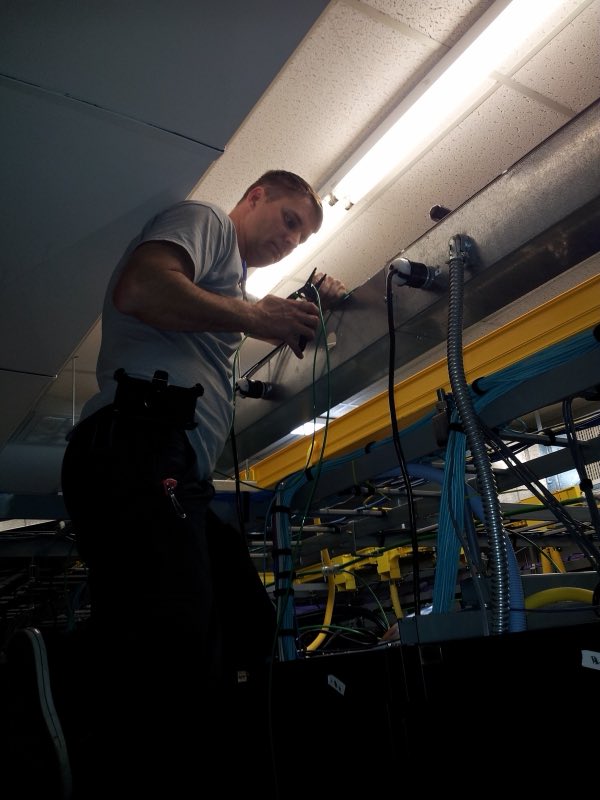 Shane running data and electrical cabling in a commercial ceiling